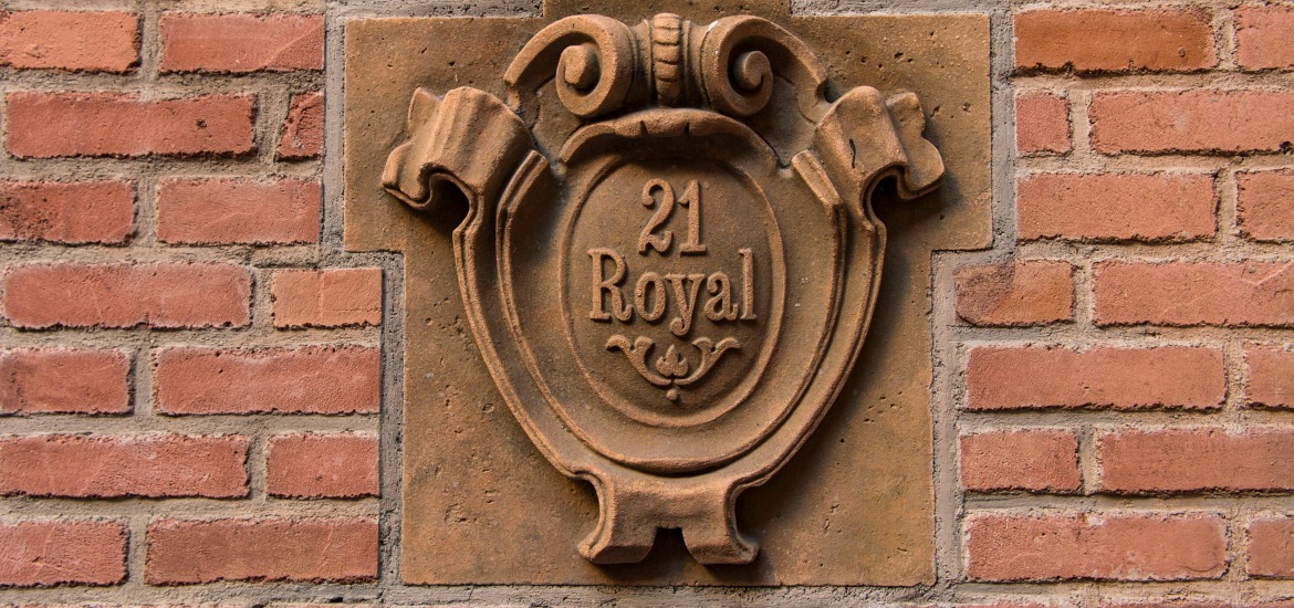 An exterior relief depicting the 21 Royal location is set into a brick wall
